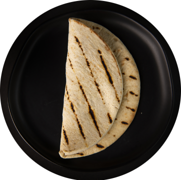 A tortilla sitting on top of a black plate.