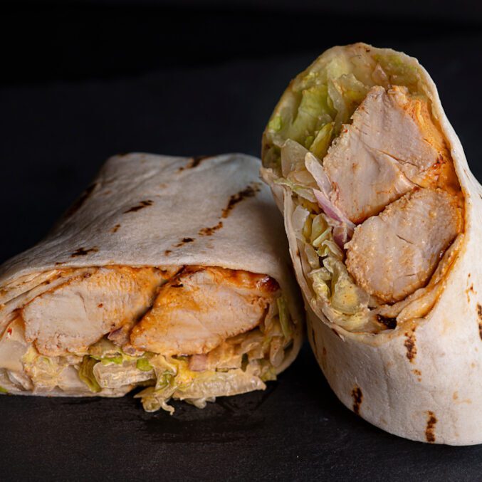 A burrito with meat and lettuce on it.