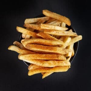 A bowl of french fries on top of a table.