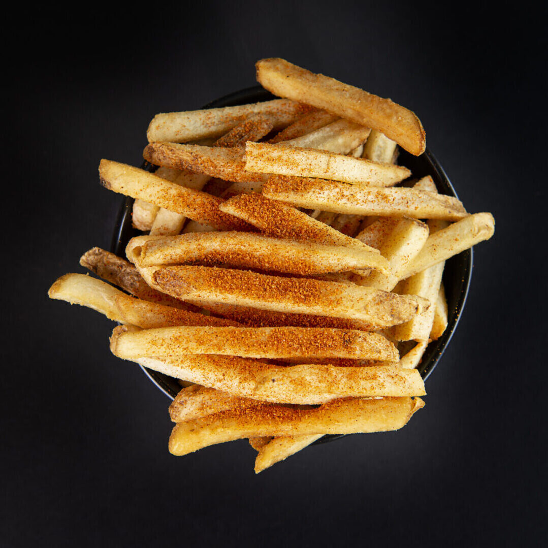 A bowl of french fries on top of a table.