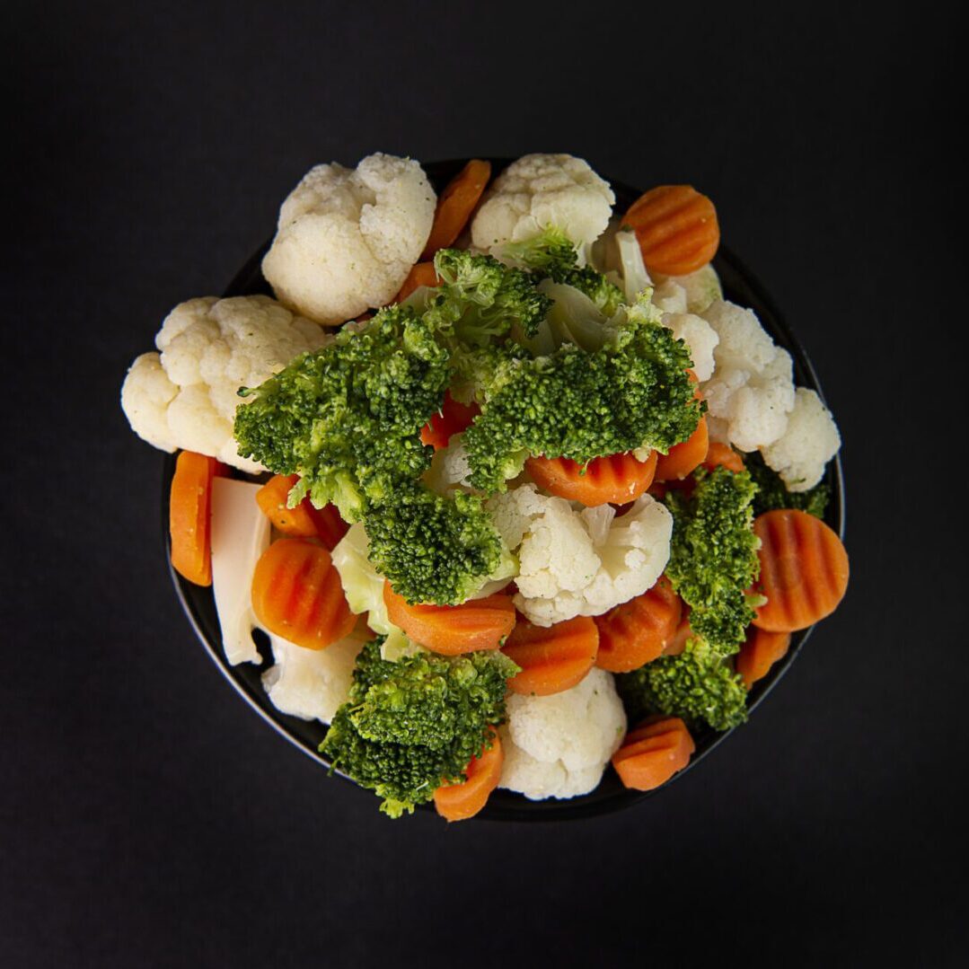 A bowl of vegetables on top of the table.