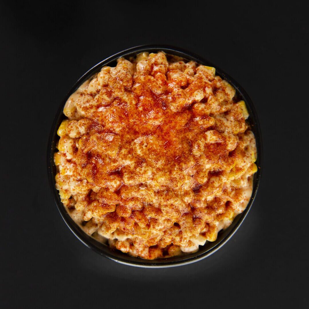 A bowl of macaroni and cheese on top of a table.
