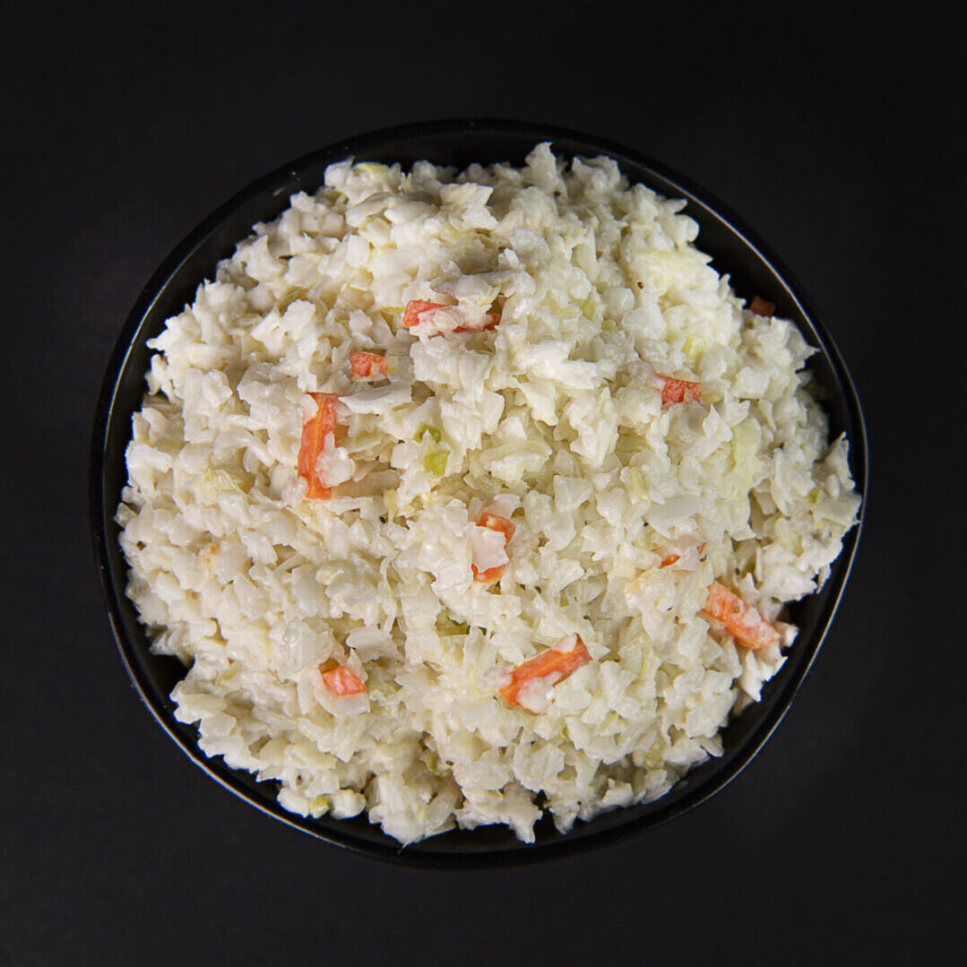 A bowl of rice with carrots and onions.