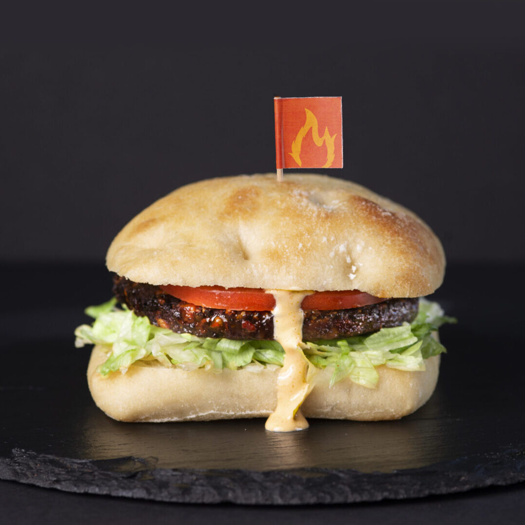 A hamburger with ketchup and lettuce on top of it.