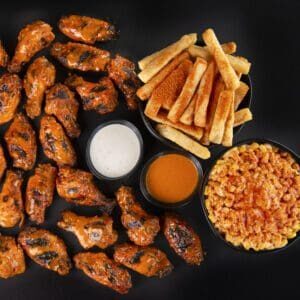 A plate of chicken, fries and macaroni and cheese.