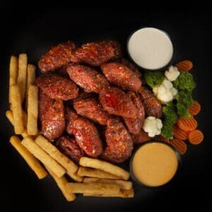 A plate of food with fries, carrots and sauce.